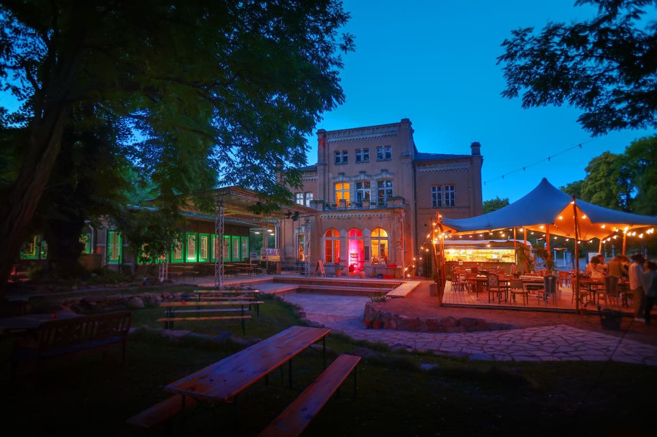 Kulturbahnhof Leisnig bei Dämmerung mit Festivallichtern.
